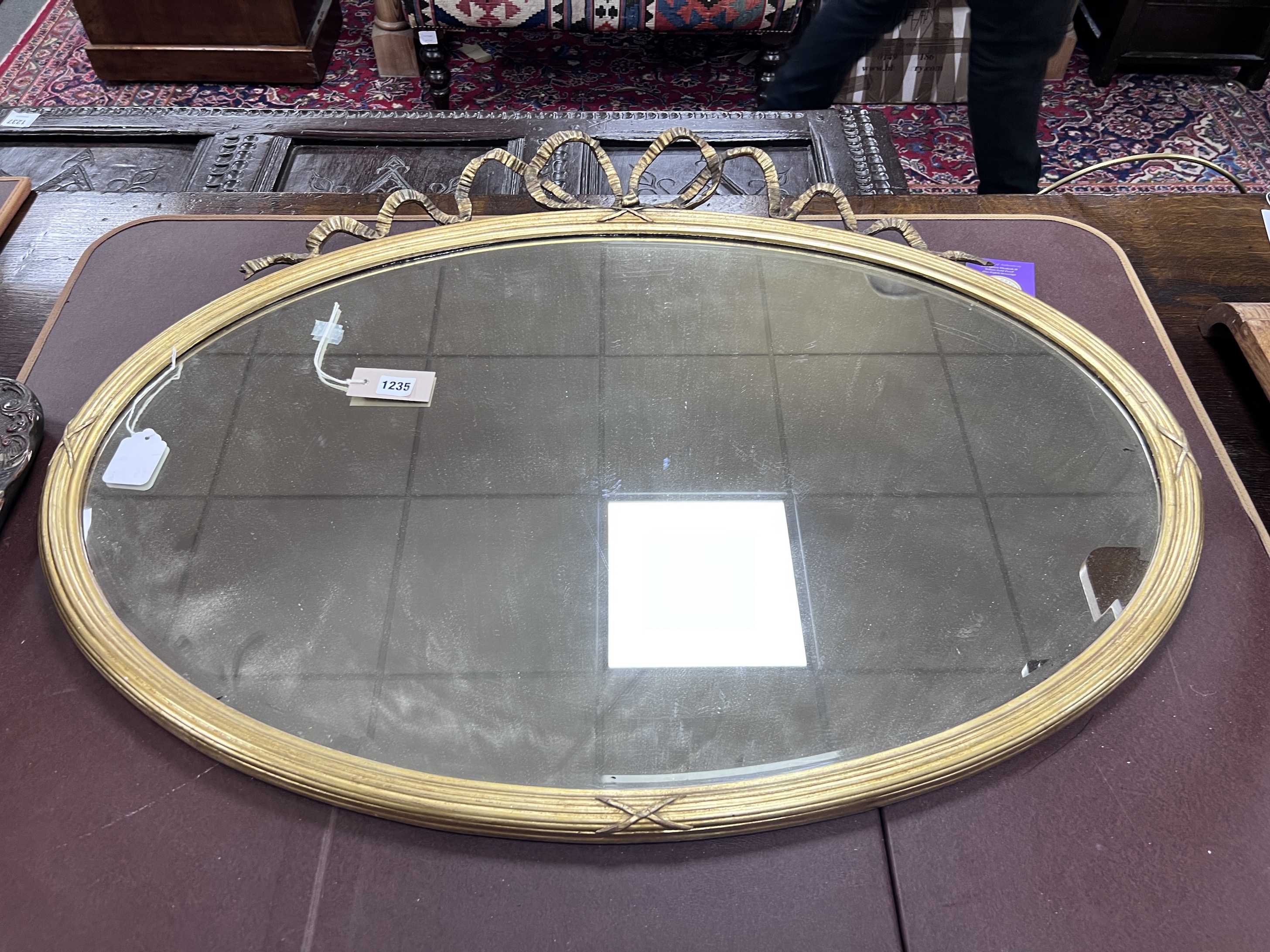 An Edwardian oval giltwood and gesso wall mirror with ribbon crest, width 93cm, height 71cm